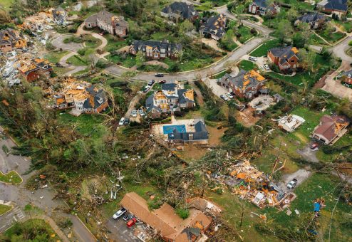 Aerial view of small settlement with destroyed houses and bent uprooted trees after hurricane