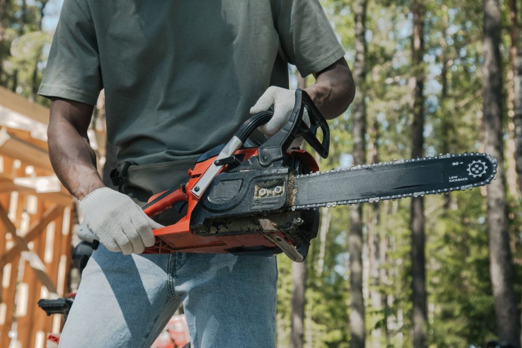 Tree worker holding a chainsaw outdoors